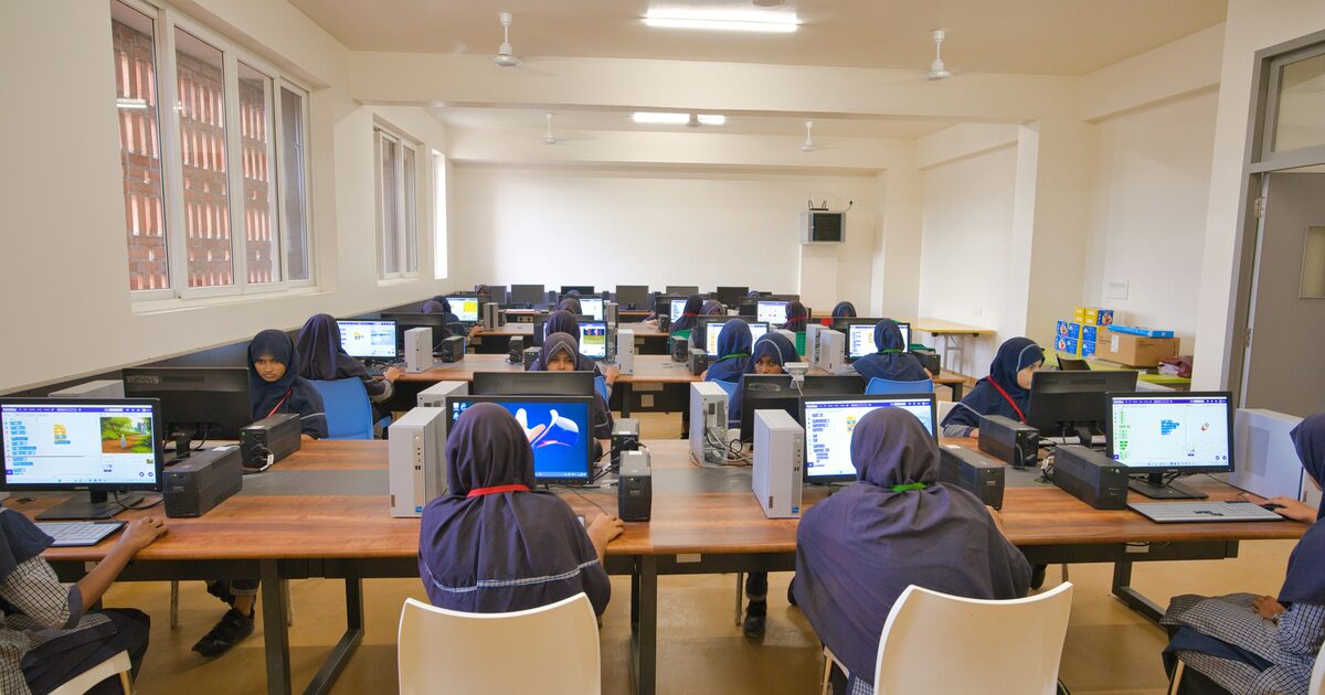 Students working at computers together in a bright school computer lab