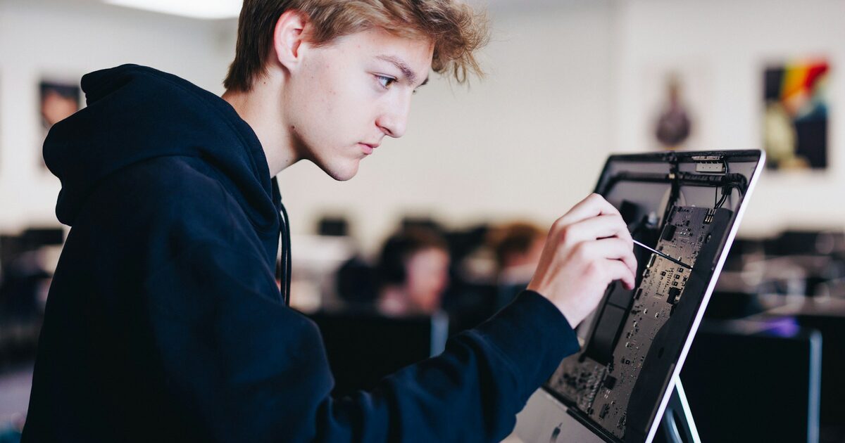 A young man concentrating while working on a laptop computer