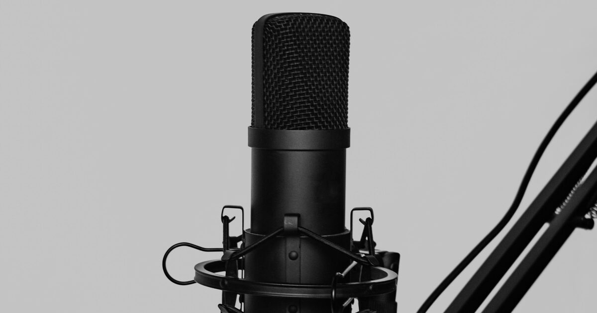 A condenser microphone mounted on a boom arm for podcasting