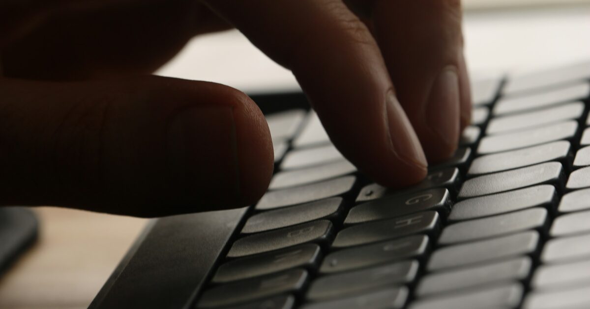 Close-up of a hand typing on a computer keyboard