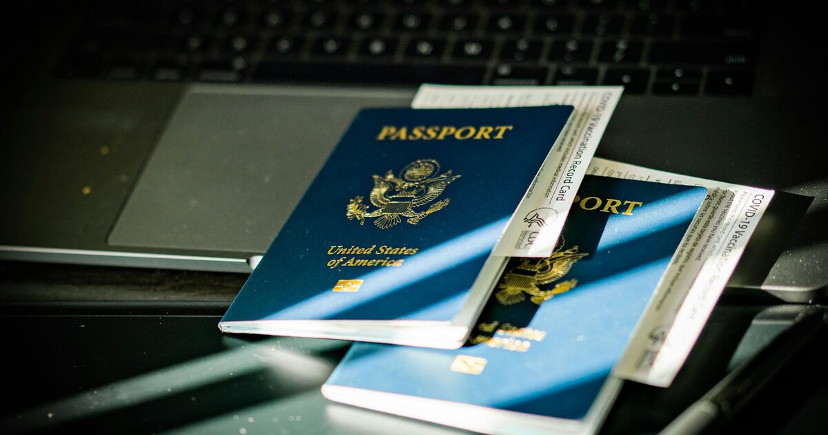 A passport resting on top of a computer keyboard