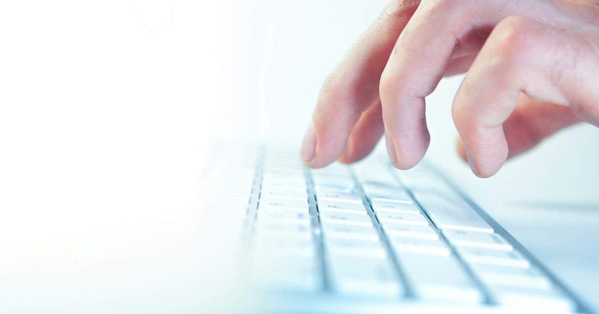 Close-up of fingers typing quickly on a computer keyboard